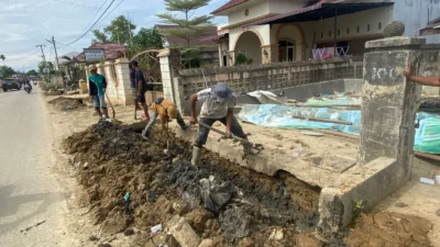 Petugas Dinas Pekerjaan Umum Pemerintah Kota Langsa membersihkan Jl. Panglima Polim di Kota Langsa, Provinsi Aceh (25/12) (Bidang Komunikasi Kebencanaan BNPB)