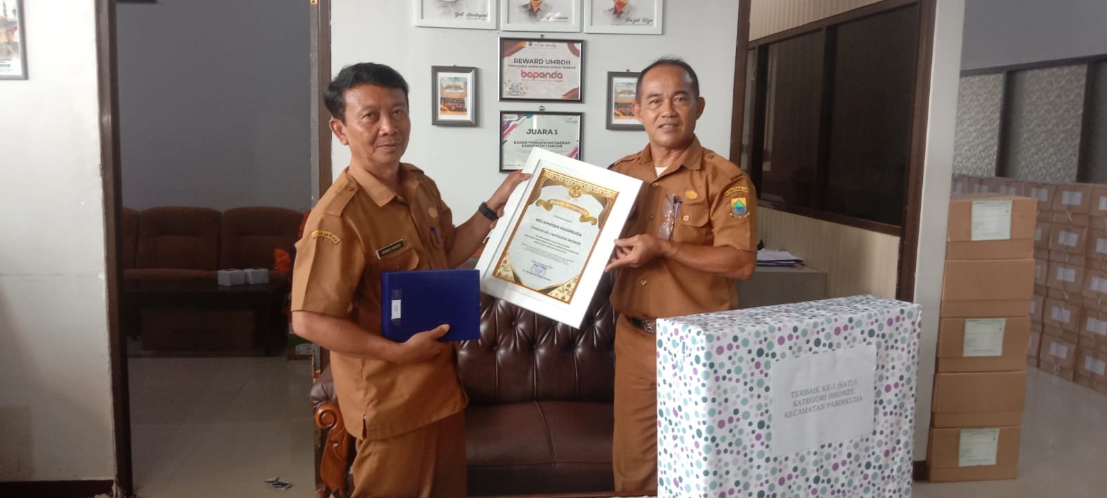PENGHARGAAN PBB-P2: Sekretaris Kecamatan Pasirkuda, Hendar Munadi bersama staf saat menunjukkan penghargaan Terbaik Ke-1 Pengelolaan PBB-P2 Tahun 2025.(DOK KECAMATAN PASIRKUDA)