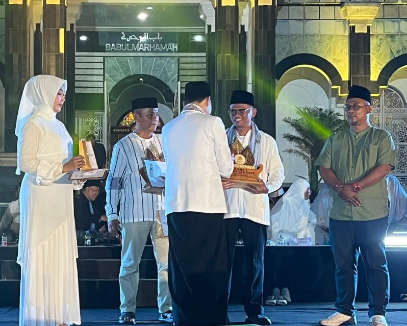 Bupati Cianjur Mohammad Wahyu Ferdian memberikan penghargaan lomba Karnaval kepada Camat Pacet Neng Didi dalam rangkaian Cianjur Fest 2026 di halaman Masjid Agung Cianjur, Sabtu (22/8) malam.(Foto : Dok. Kecamatan Pacet)